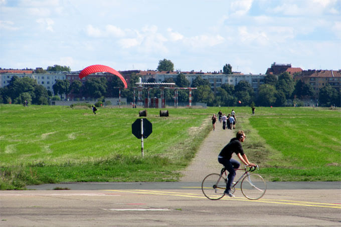 Drachensteiger und Radfahrer im Tempelhofer Park